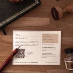Verso de la carte cadeau de L’atelier de l’écureuil, avec code, date de validité et QR code, posé sur une table en bois à côté d’un porte-plume et d’un tampon.