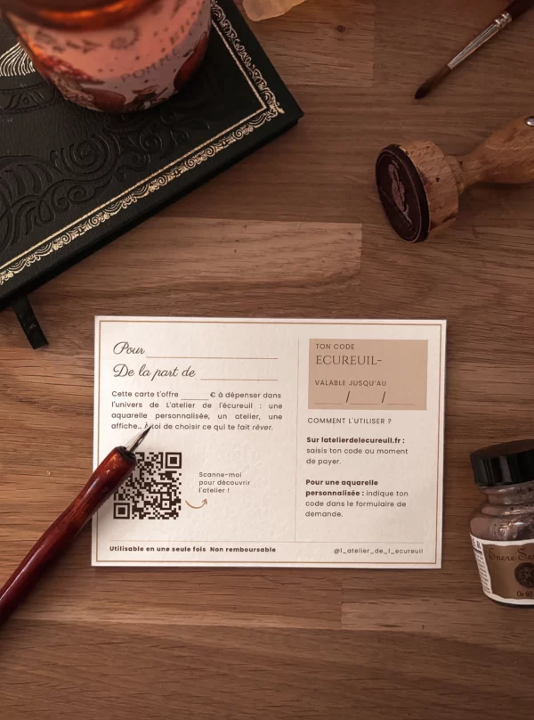 Verso de la carte cadeau de L’atelier de l’écureuil, avec code, date de validité et QR code, posé sur une table en bois à côté d’un porte-plume et d’un tampon.